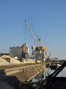 Teilnehmer bedienen einen schienengebundenen Portalkran beim Umschlag von Schüttgut
